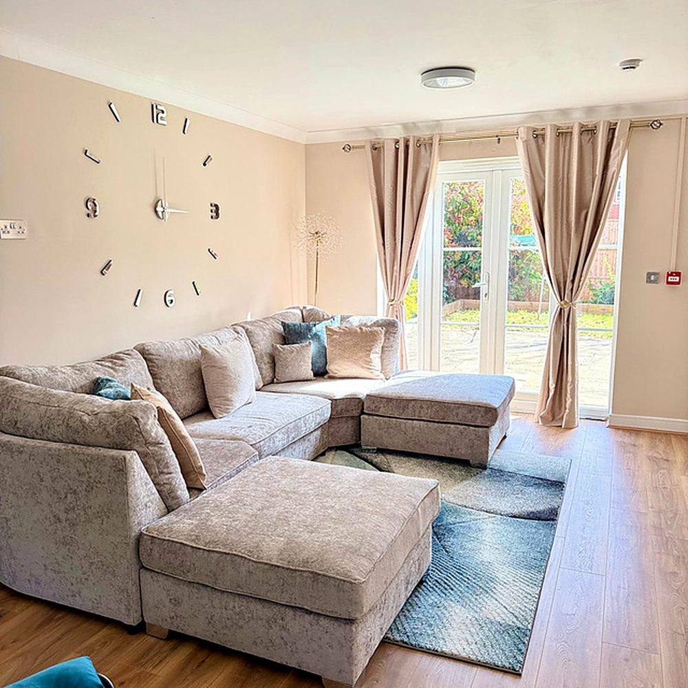 The living room at Hammond House, with soft seating arranged around a low table and daylight from a large window.
